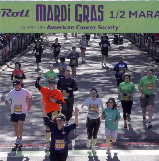 Writer Karen Schwartz, foreground right in white shirt, crosses the finish line with her daughter, who joined her at the end of the race and helped her to the medical tent at the Rock 'n' Roll Mardi Gras Half Marathon in New Orleans.